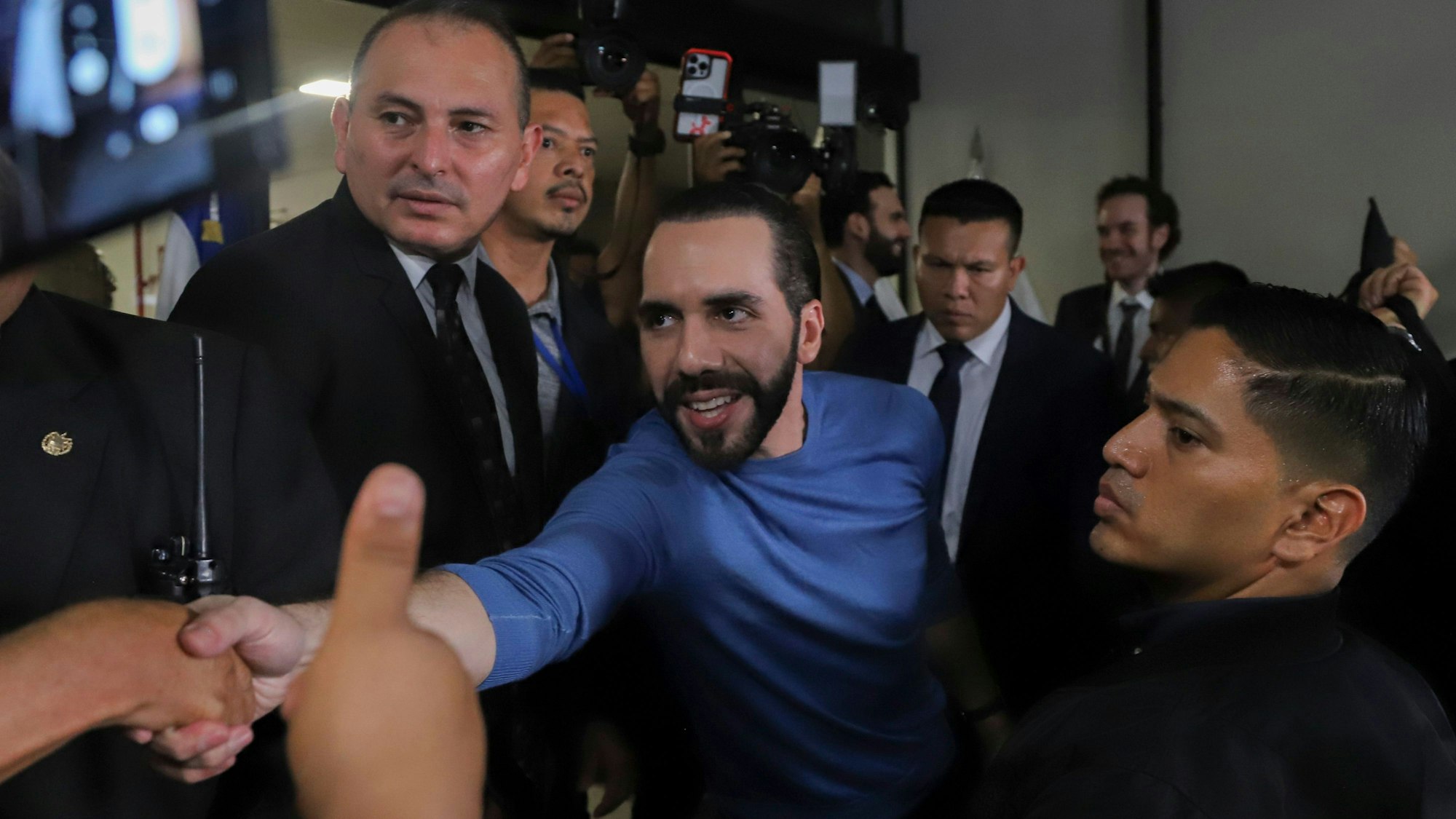 ARCHIV - 27.10.2023, El Salvador, Salvador Melendez: Nayib Bukele (M) drückt einem Anhänger die Hand, nachdem er sich als Präsidentschaftskandidat der Partei Nuevas Ideas (Neue Ideen) angemeldet hat. Für viele ist Präsident Bukele ein Volksheld. Für andere ein autoritärer Herrscher. (zu dpa: ««Coolster Diktator der Welt» tritt zweite Amtszeit in El Salvador an») Foto: Salvador Melendez/AP/dpa +++ dpa-Bildfunk +++