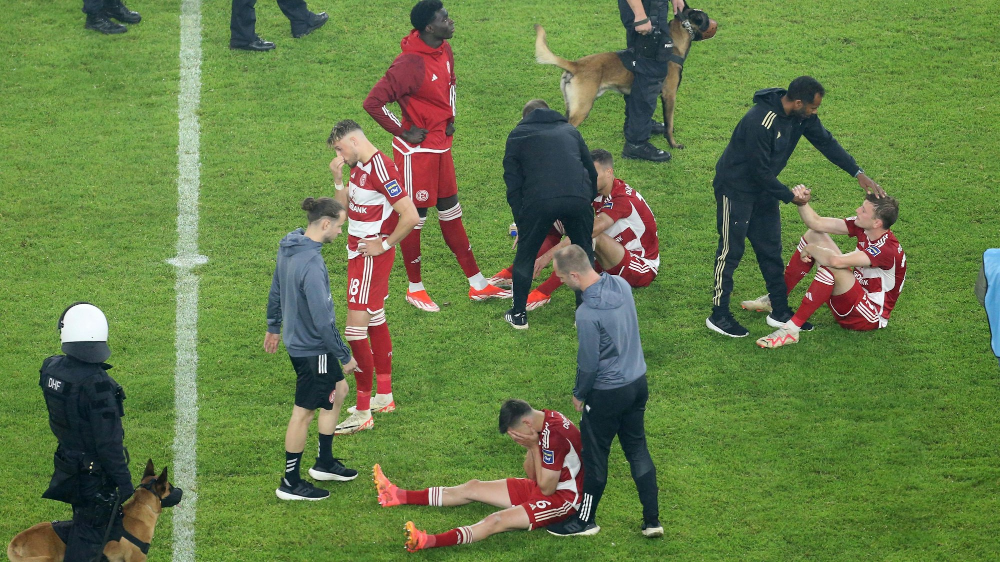 Der Düsseldorfer Trainer Daliel Thioune (r) tröstet seine Spieler.