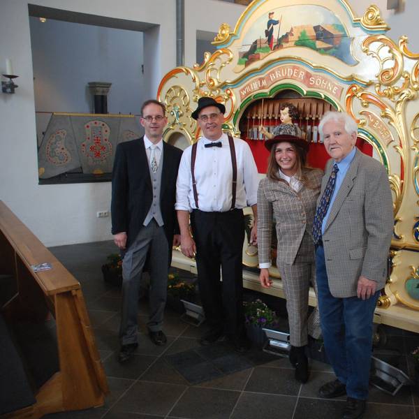 Drei Männer und eine Frau stehen in der Kirche in Zülpich vor der Kirmesorgel. Von links sind Holger Weimbs, Toni Schleifer, Eva Schleifer und Jakob Schleifer zu sehen.