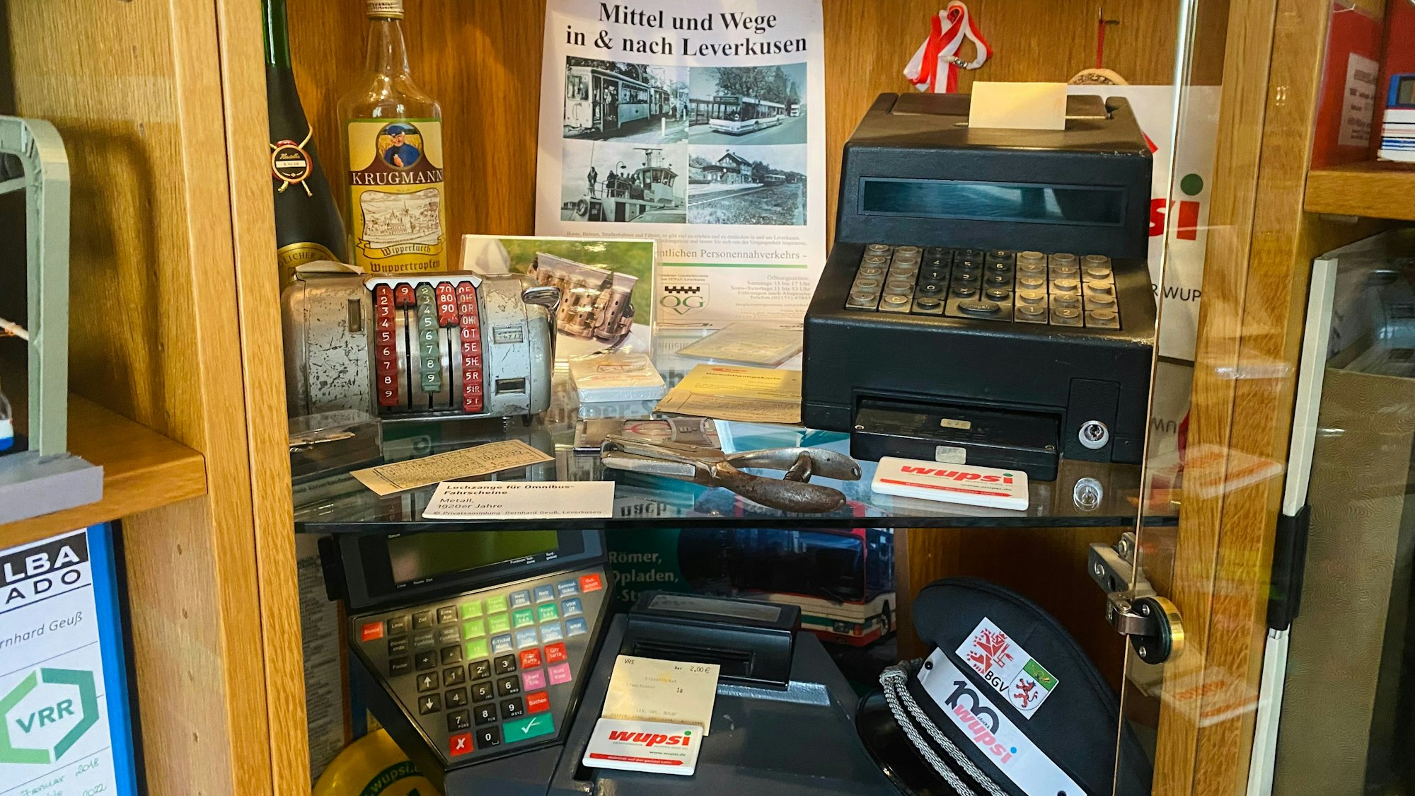 In einem Regal liegen unter anderem ein Galoppwechsler, alte Fahrscheine und eine Stanzerzange.