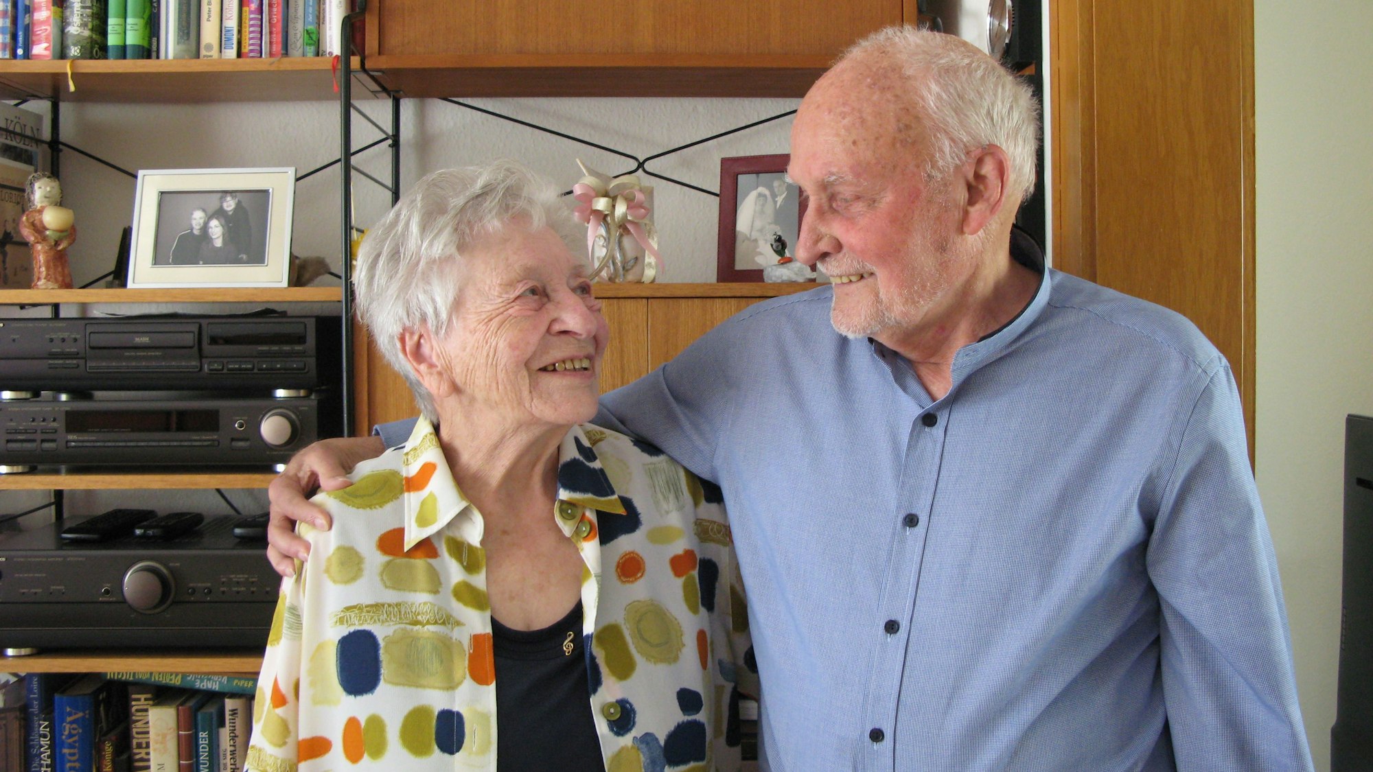 Ein grauhaariger Mann und eine grauhaarige Frau sehen sich tief in die Augen.