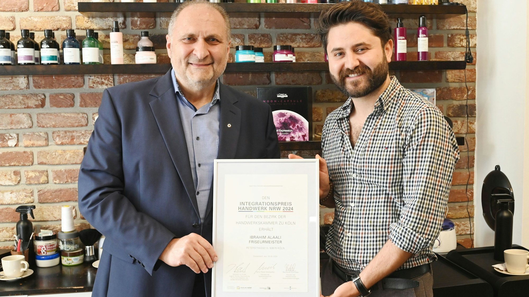 Zwei Männer halten eine Urkunde, während sie in einem Friseursalon stehen.