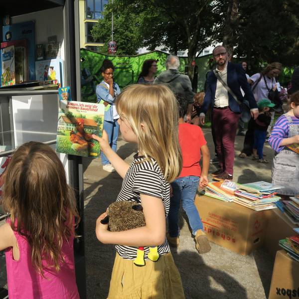 Kinder beim Lesen, Einsortieren der Bücher in den neuen Bücherschrank im Leo-Amann-Park.