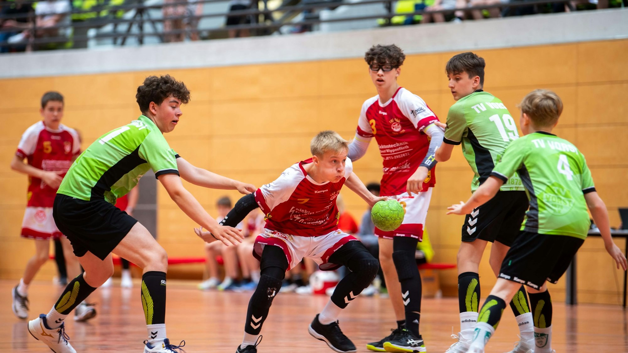 Tim Wipperfürth führt den Ball, drei Spieler der gegnerischen Mannschaft bewegen sich um in herum.