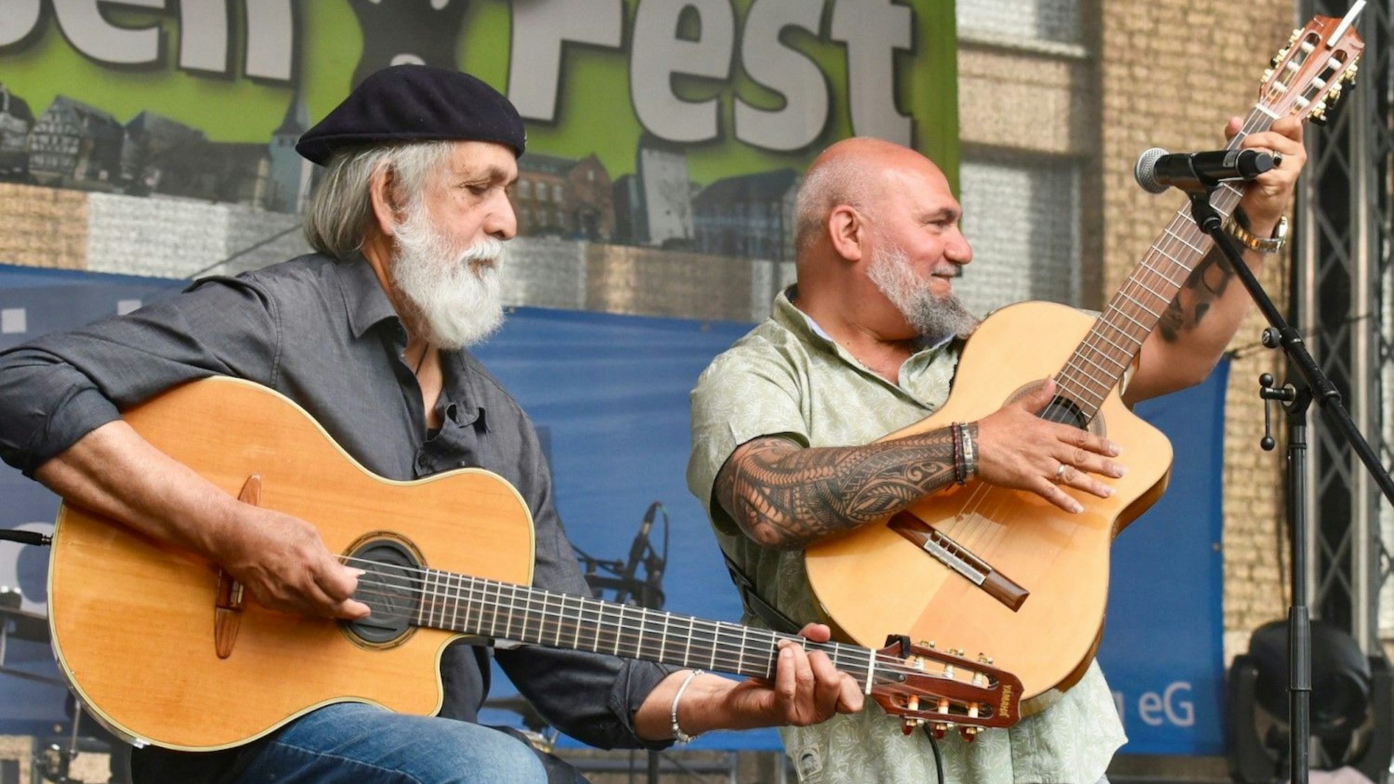 Zwei ältere Männer mit Gitarren.