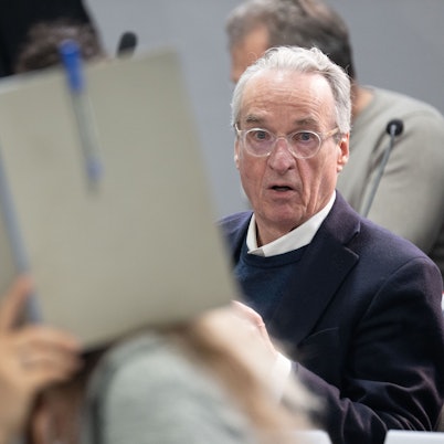 dpatopbilder - 28.05.2024, Hessen, Frankfurt/Main: Der Hauptangeklagte Heinrich XIII. Prinz Reuß sitzt bei der Fortsetzung des Prozesses gegen eine mutmaßliche ·Reichsbürger-Gruppe· um um Prinz Reuß auf der Anklagebank hinter einer Mitangeklagten, die ihr Gesicht mit einer Mappe verdeckt. Die Bundesanwaltschaft legt den insgesamt neun Angeklagten unter anderem die Mitgliedschaft in einer terroristischen Vereinigung zur Last. Foto: Boris Roessler/dpa-POOL/dpa +++ dpa-Bildfunk +++