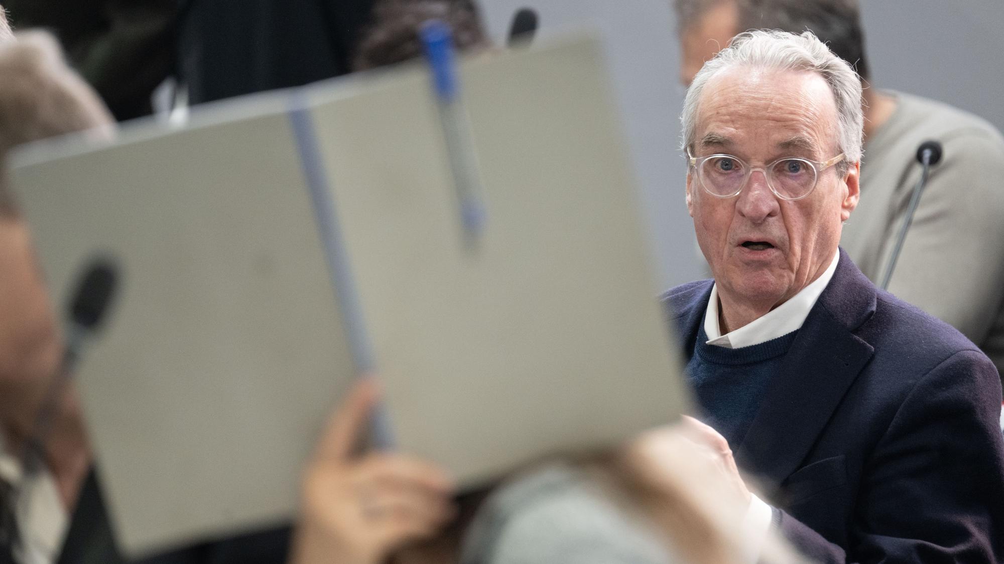 dpatopbilder - 28.05.2024, Hessen, Frankfurt/Main: Der Hauptangeklagte Heinrich XIII. Prinz Reuß sitzt bei der Fortsetzung des Prozesses gegen eine mutmaßliche ·Reichsbürger-Gruppe· um um Prinz Reuß auf der Anklagebank hinter einer Mitangeklagten, die ihr Gesicht mit einer Mappe verdeckt. Die Bundesanwaltschaft legt den insgesamt neun Angeklagten unter anderem die Mitgliedschaft in einer terroristischen Vereinigung zur Last. Foto: Boris Roessler/dpa-POOL/dpa +++ dpa-Bildfunk +++