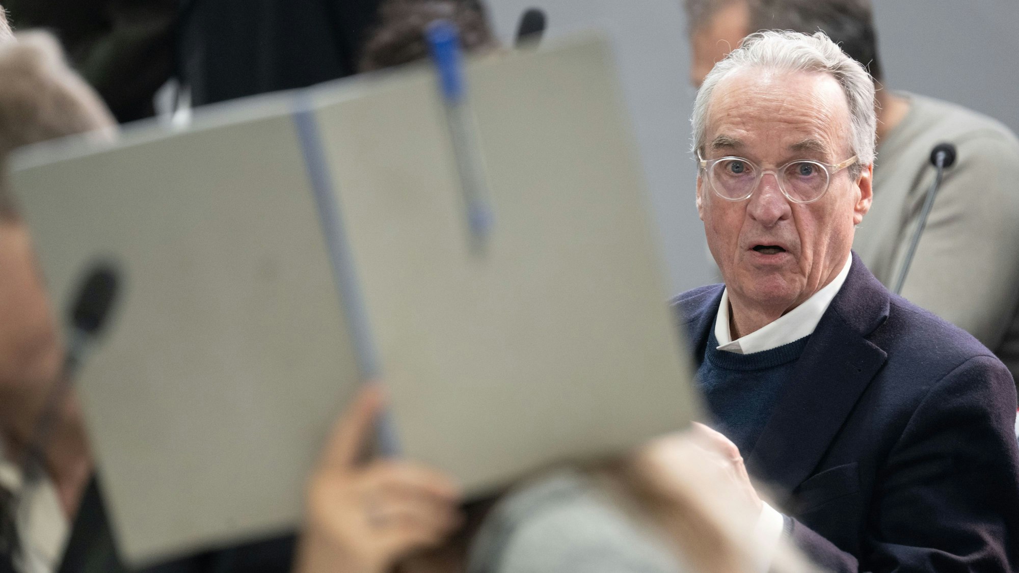 dpatopbilder - 28.05.2024, Hessen, Frankfurt/Main: Der Hauptangeklagte Heinrich XIII. Prinz Reuß sitzt bei der Fortsetzung des Prozesses gegen eine mutmaßliche ·Reichsbürger-Gruppe· um  um Prinz Reuß auf der Anklagebank hinter einer Mitangeklagten, die ihr Gesicht mit einer Mappe verdeckt. Die Bundesanwaltschaft legt den insgesamt neun Angeklagten unter anderem die Mitgliedschaft in einer terroristischen Vereinigung zur Last. Foto: Boris Roessler/dpa-POOL/dpa +++ dpa-Bildfunk +++