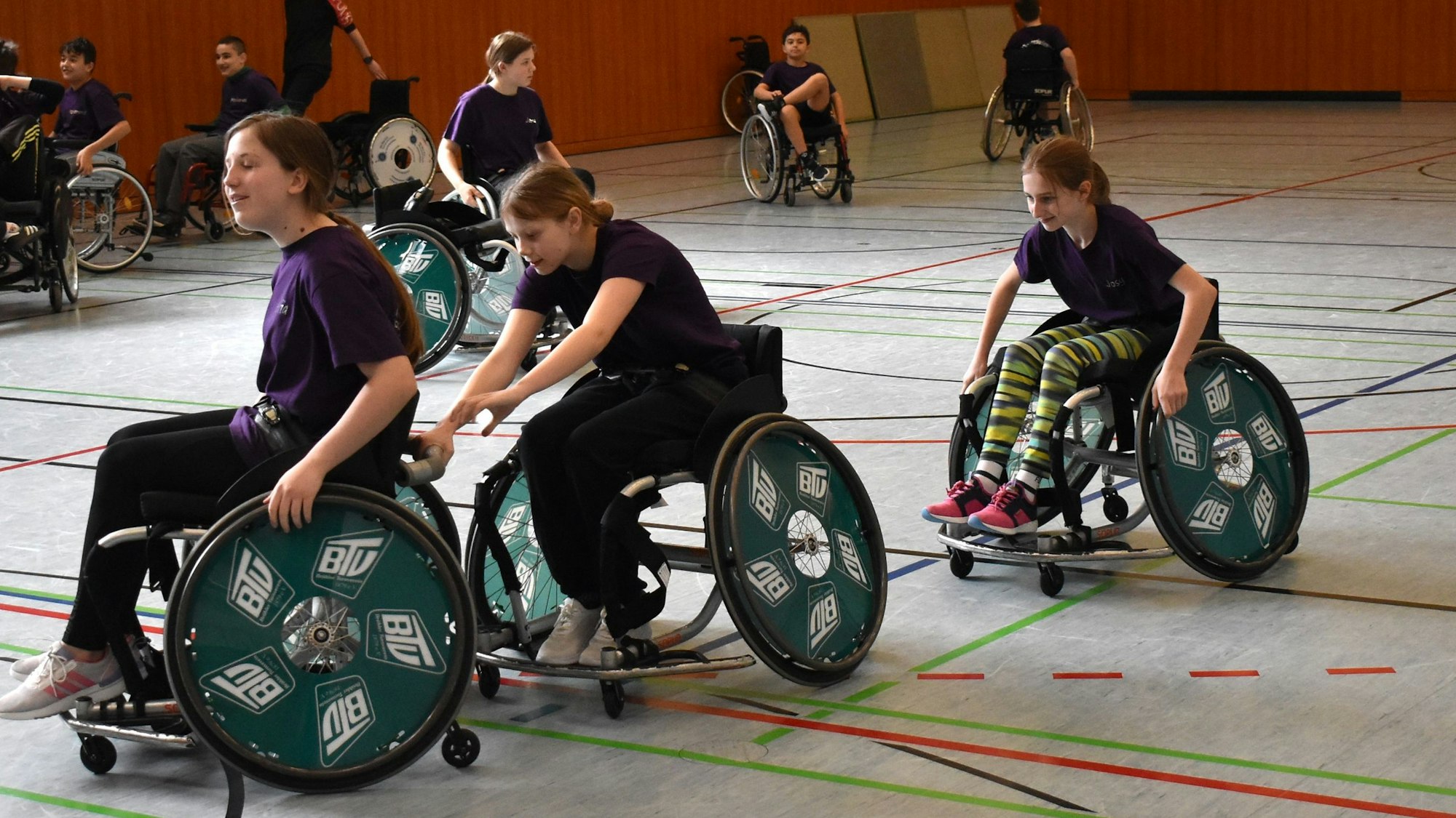 Zu sehen sind Jugendliche im Rollstuhl beim Sport.