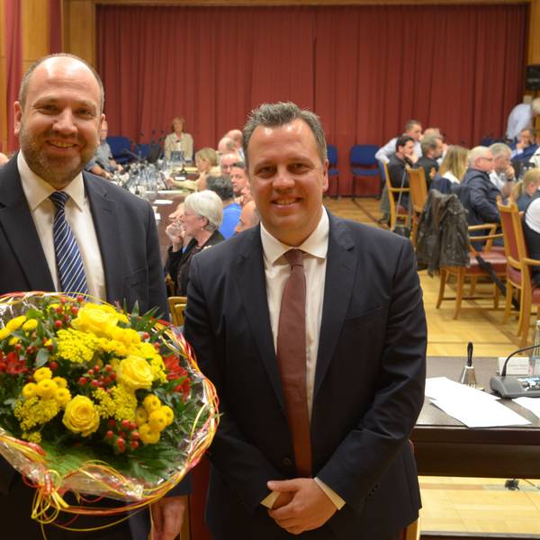 René Strotkötter (l.) und Sacha Reichelt stehen nebeneinander im Ratssaal, hinter ihnen sitzen Stadtverordnete an ihren Tischen.