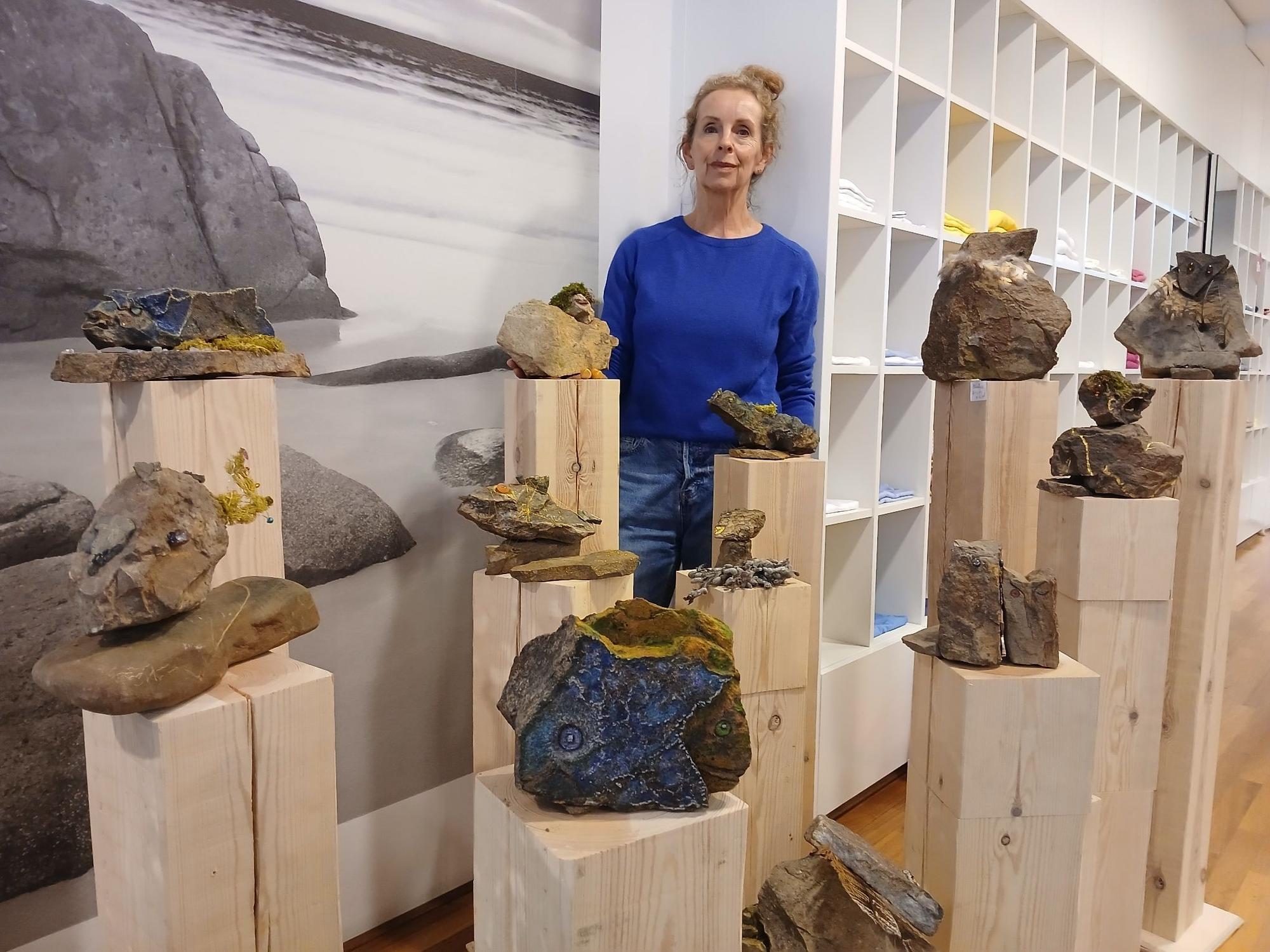 Eine Frau mit Steinplastiken auf Holzstelen