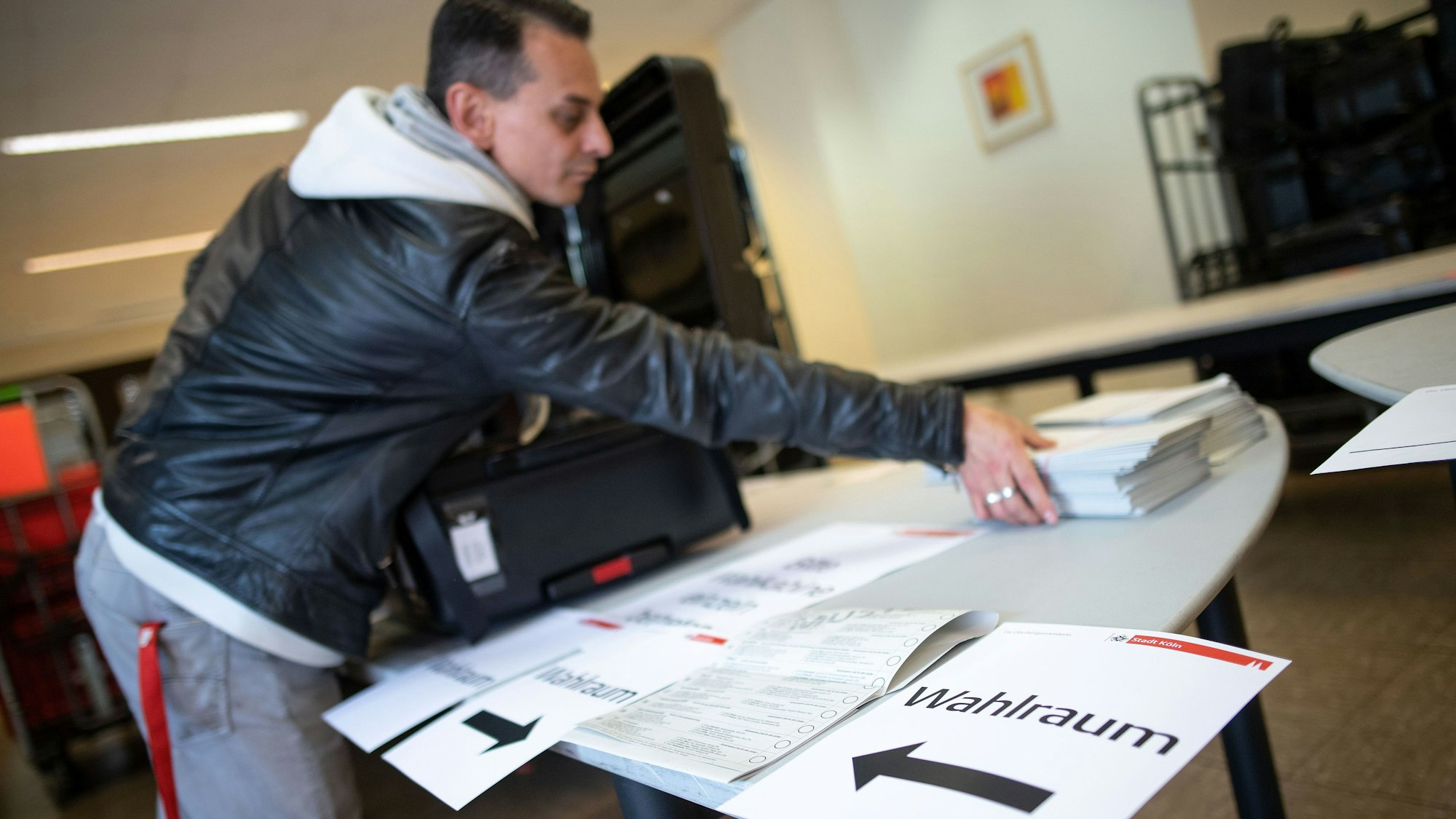 Ein Mitarbeiter packt im Wahlamt der Stadt Köln einen Wahlkoffer für die Europawahl (Archivbild von 2019).
