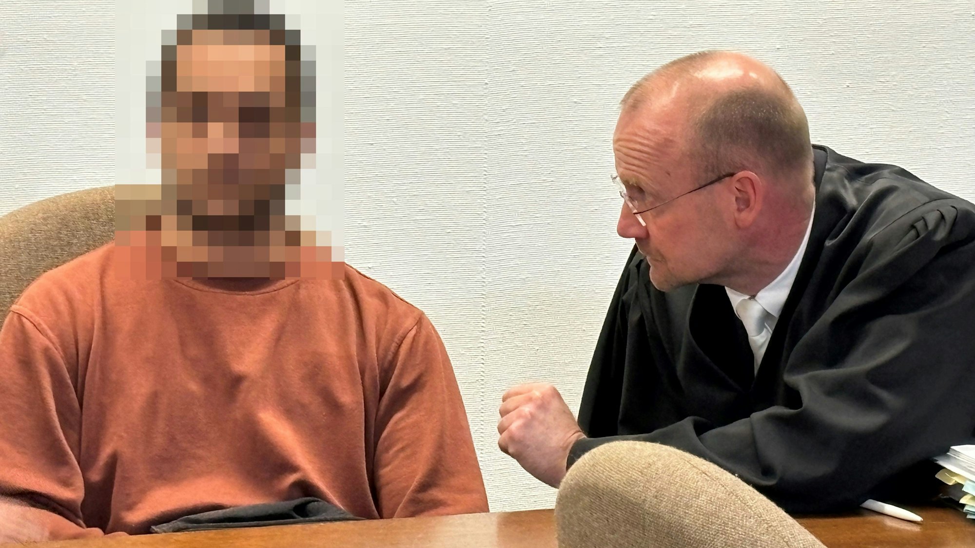 Der angeklagte Vater sitzt neben seinem Verteidiger im Saal des Landgerichts.