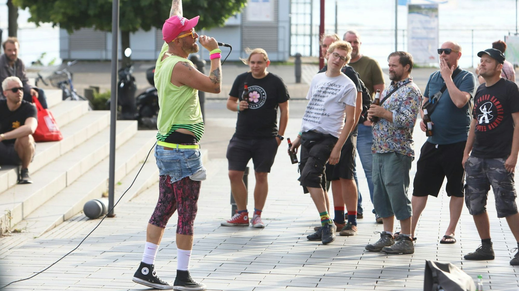 Ein Musiker mit Mikrofon singt vor einer Gruppe junger Zuhörer.