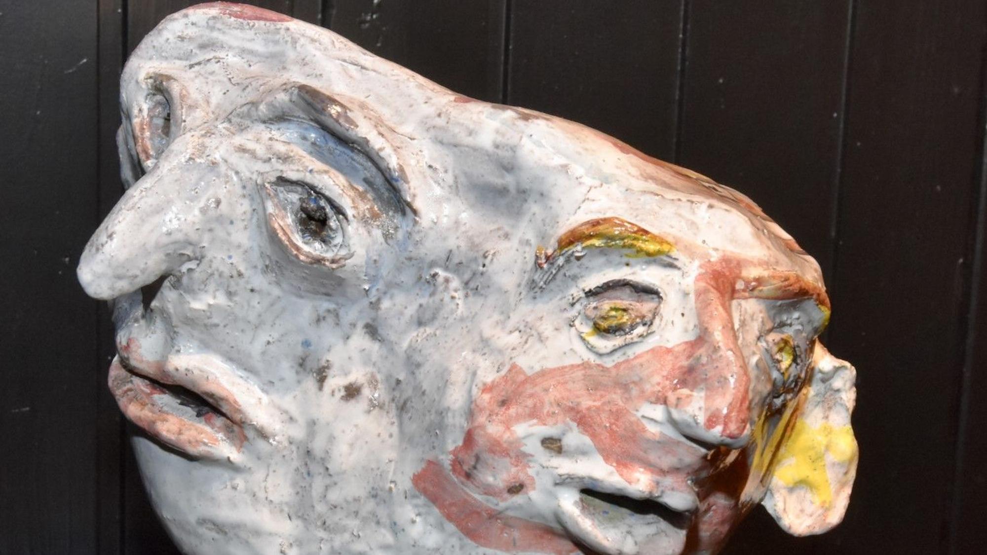 Eine Terracotta-Skulptur, die zwei miteinander verbundene Köpfe zeigt.