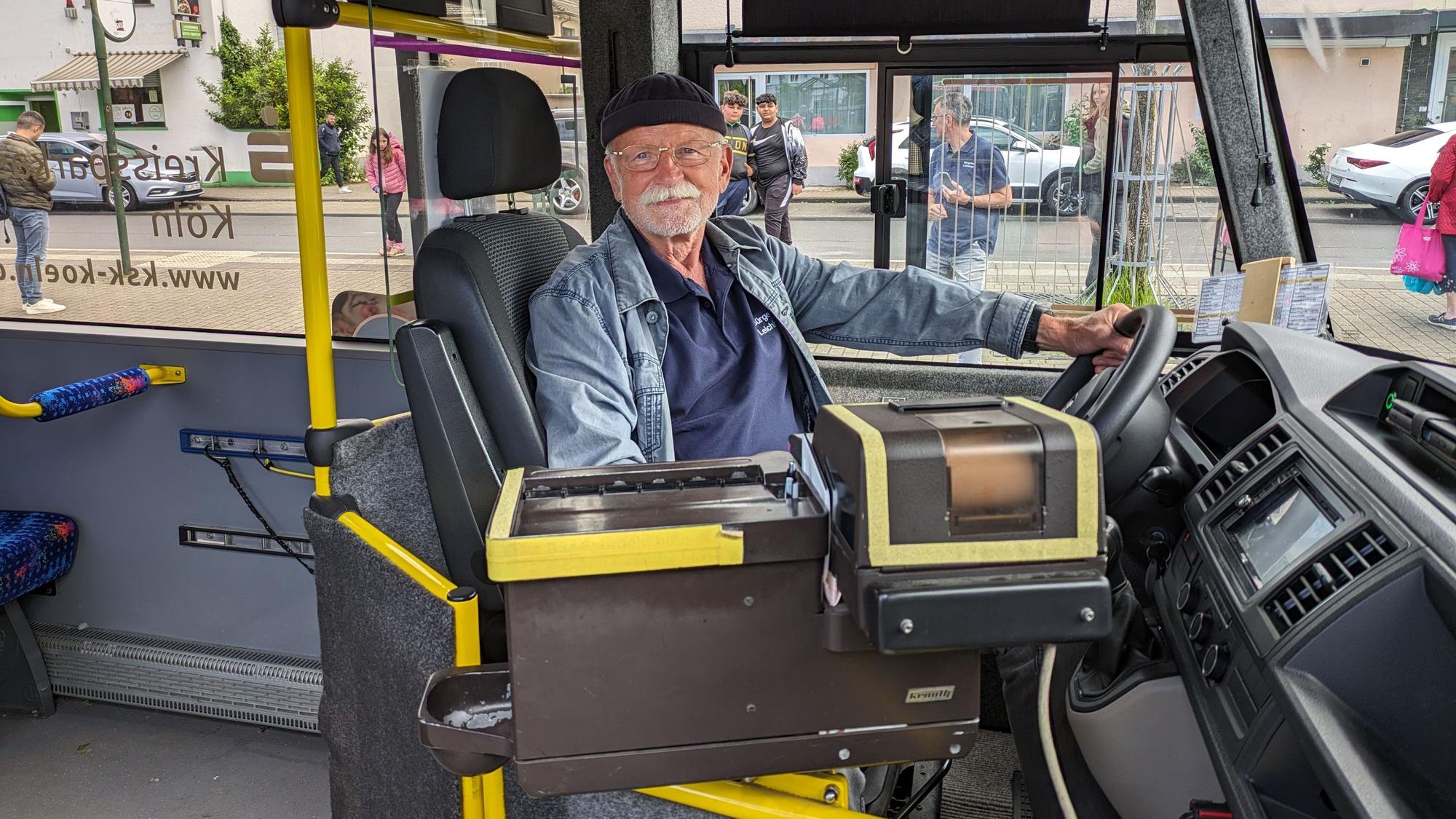 Ein bärtiger Mann sitzt am Steuer eines Busses.