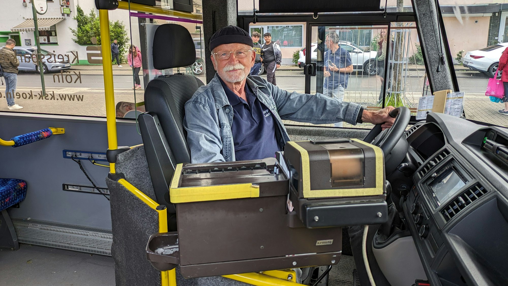Ein bärtiger Mann sitzt am Steuer eines Busses.