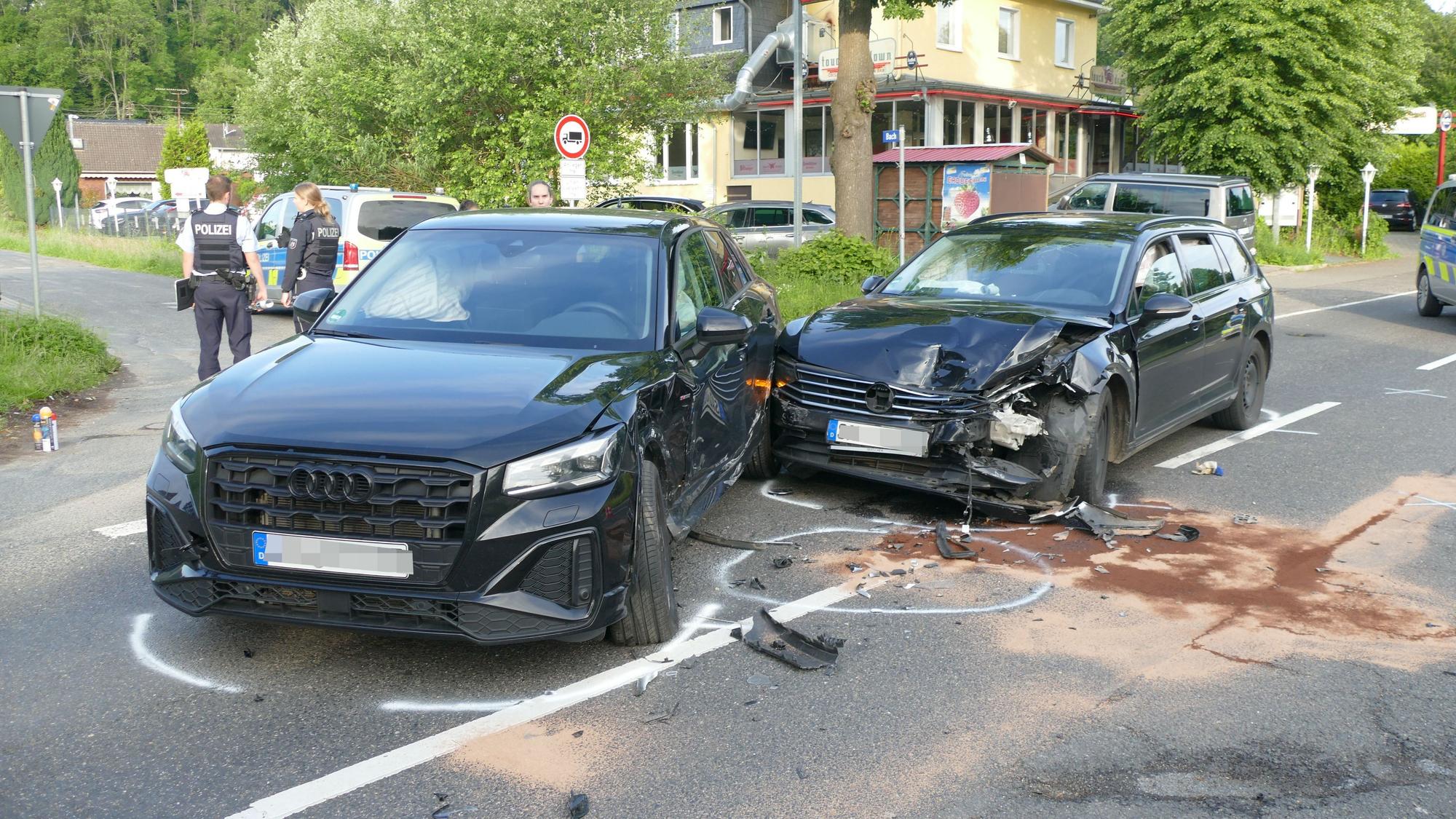 Zwei beschädigte Autos stehen auf einer Straße.
