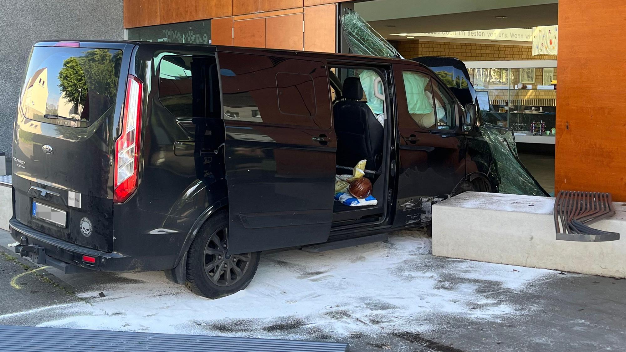 Ein Transporter steht in der zerstörten Glasfront eines Schulgebäudes.