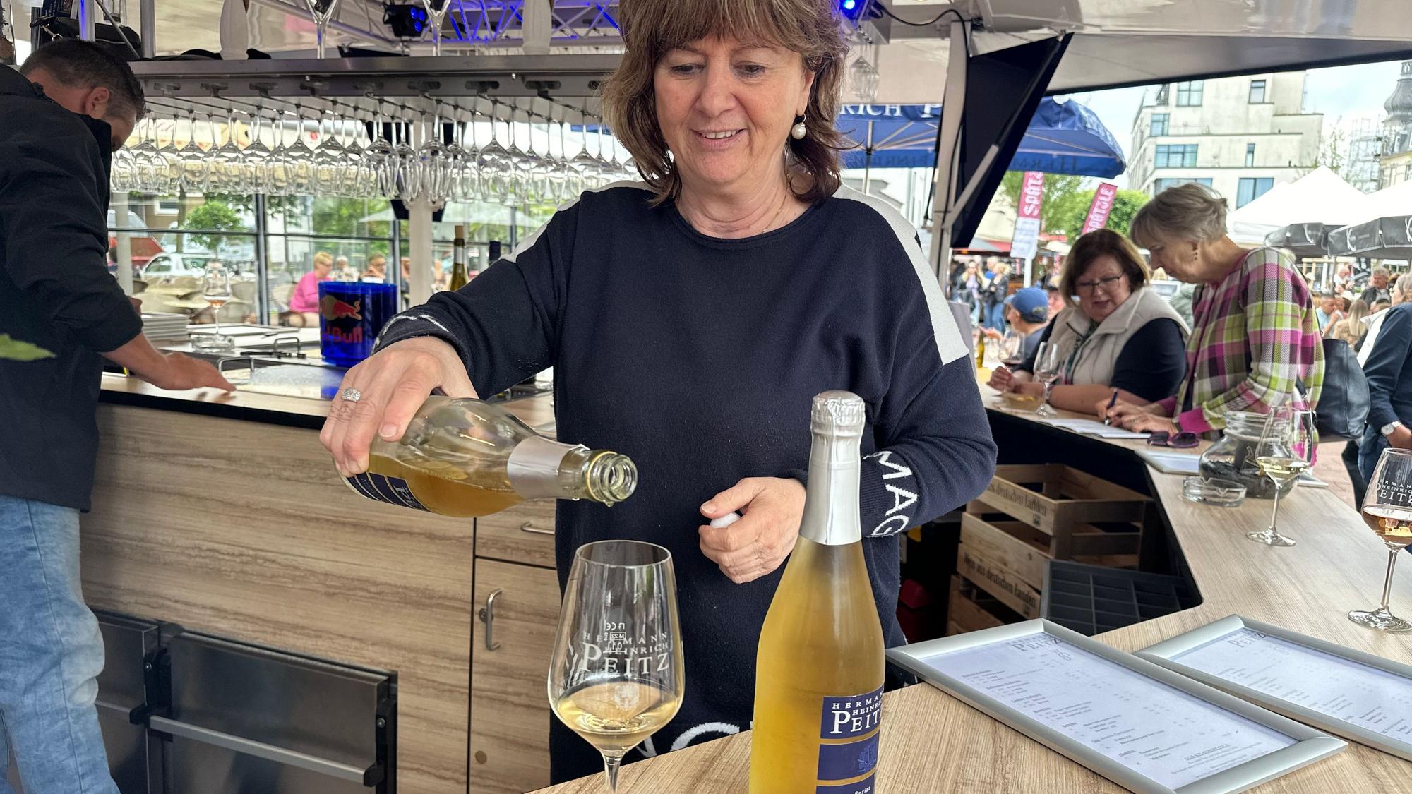 Sabine Peitz schenkt ein Glas Traubensaft Sprizz ein.