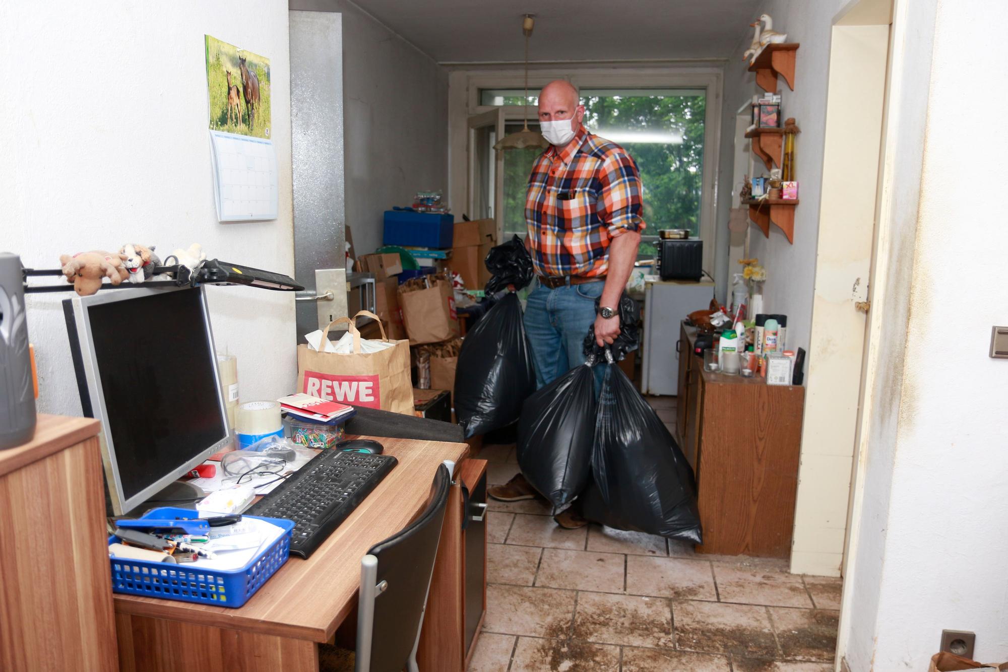 Der Eigentümer der Wohnung kommt den Mietern zu Hilfe und entsorgt einige Müllsäcke.