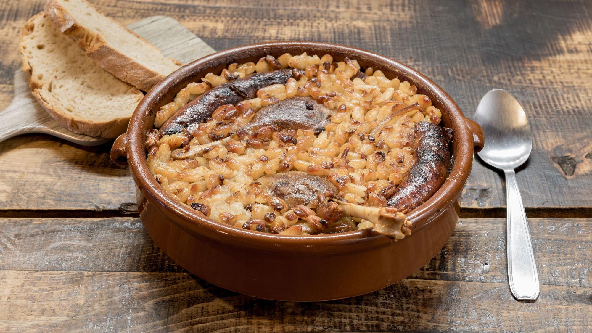 Eine Schale mit Cassoulet auf einem Holztisch