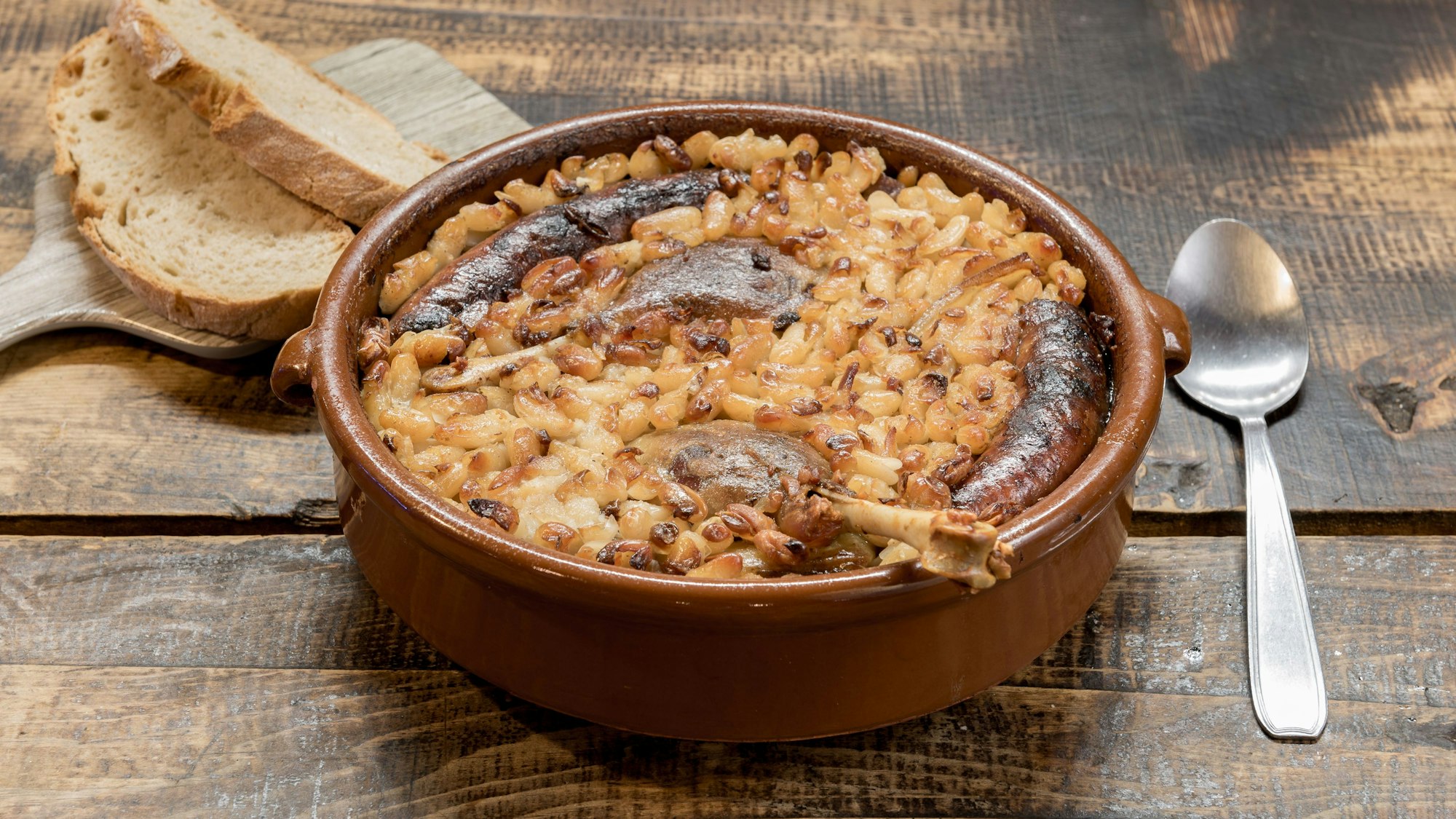 Eine Schale mit Cassoulet auf einem Holztisch