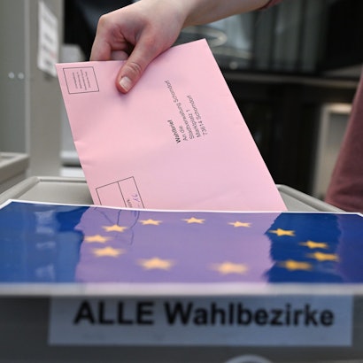 Ein Wahlbrief mit einem Stimmzettel für die Europawahl wird im Rathaus in einem Wahllokal für die Briefwahl in eine Wahlurne gesteckt.