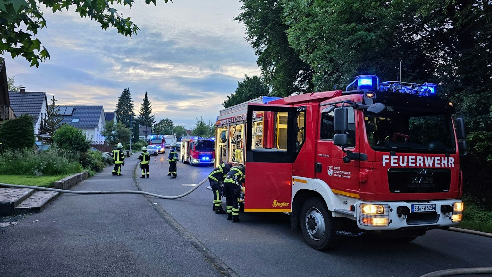 Mehrere Löschfahrzeuge der Freiwilligen Feuerwehr Königswinter stehen auf einer Straße.