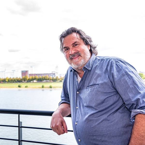 Thomas Reis steht auf seinem Balkon, hinter ihm ist der Rhein zu sehen.
