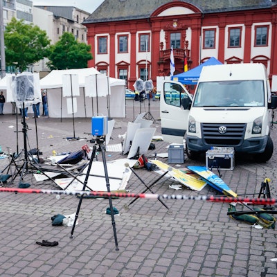 Baden-Württemberg, Mannheim: Mitarbeiter der Spurensicherung stehen auf dem Marktplatz hinter einem zertrümmerten Stand.