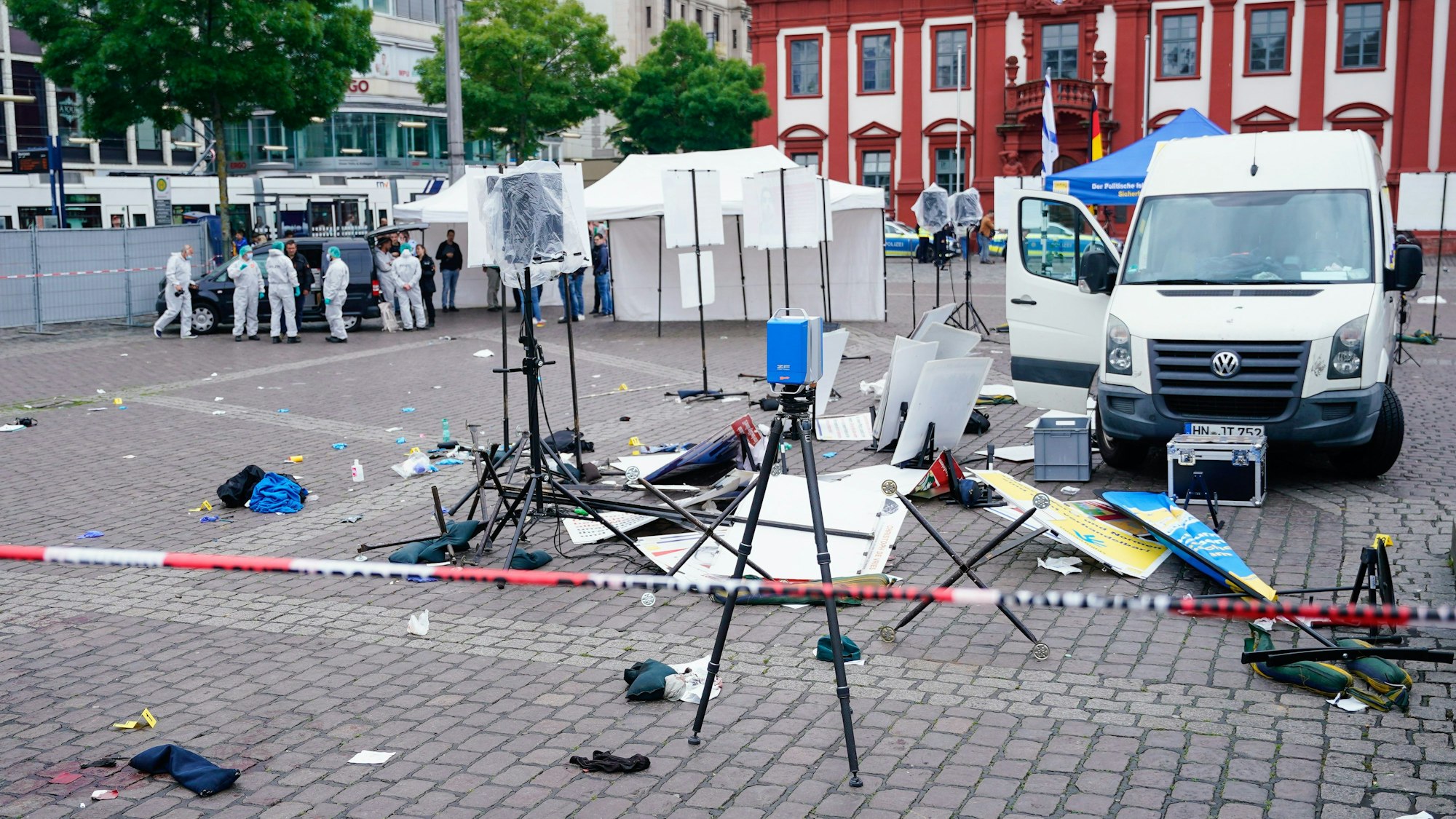 Baden-Württemberg, Mannheim: Mitarbeiter der Spurensicherung stehen auf dem Marktplatz hinter einem zertrümmerten Stand.