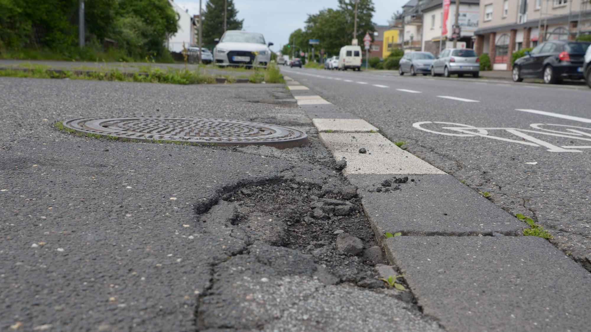 Der Asphalt weist Löcher und Risse auf.