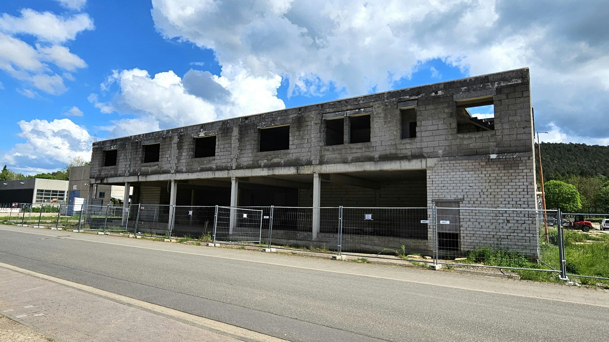 Blick auf den direkt an der Straße stehenden Rohbau.