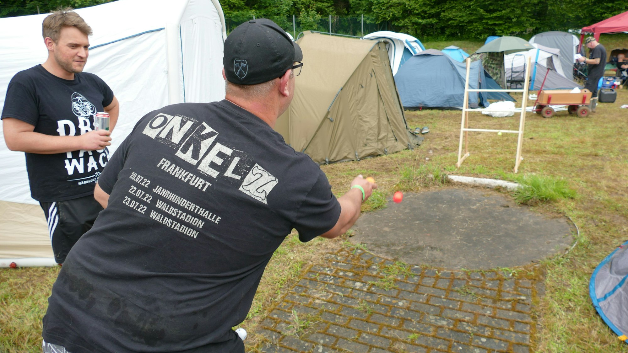 Ein Mann wirft einen Ball in Richtung einer Leiter.