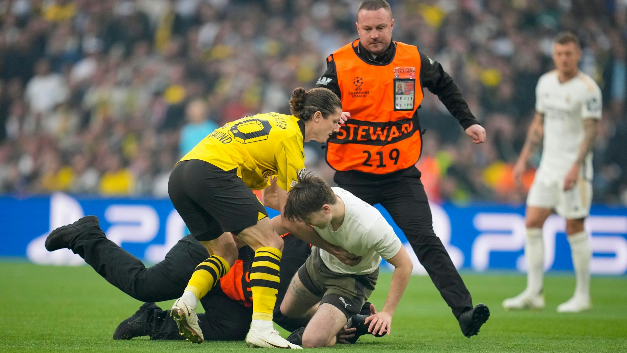 Dortmunds Marcel Sabitzer hindert einen Fan daran, seinen Lauf über den Rasen fortzusetzen.