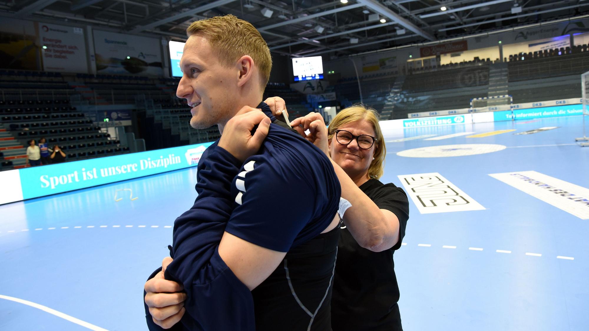 Handballer Tilen Kodrin bekommt einen Sensor angelegt.