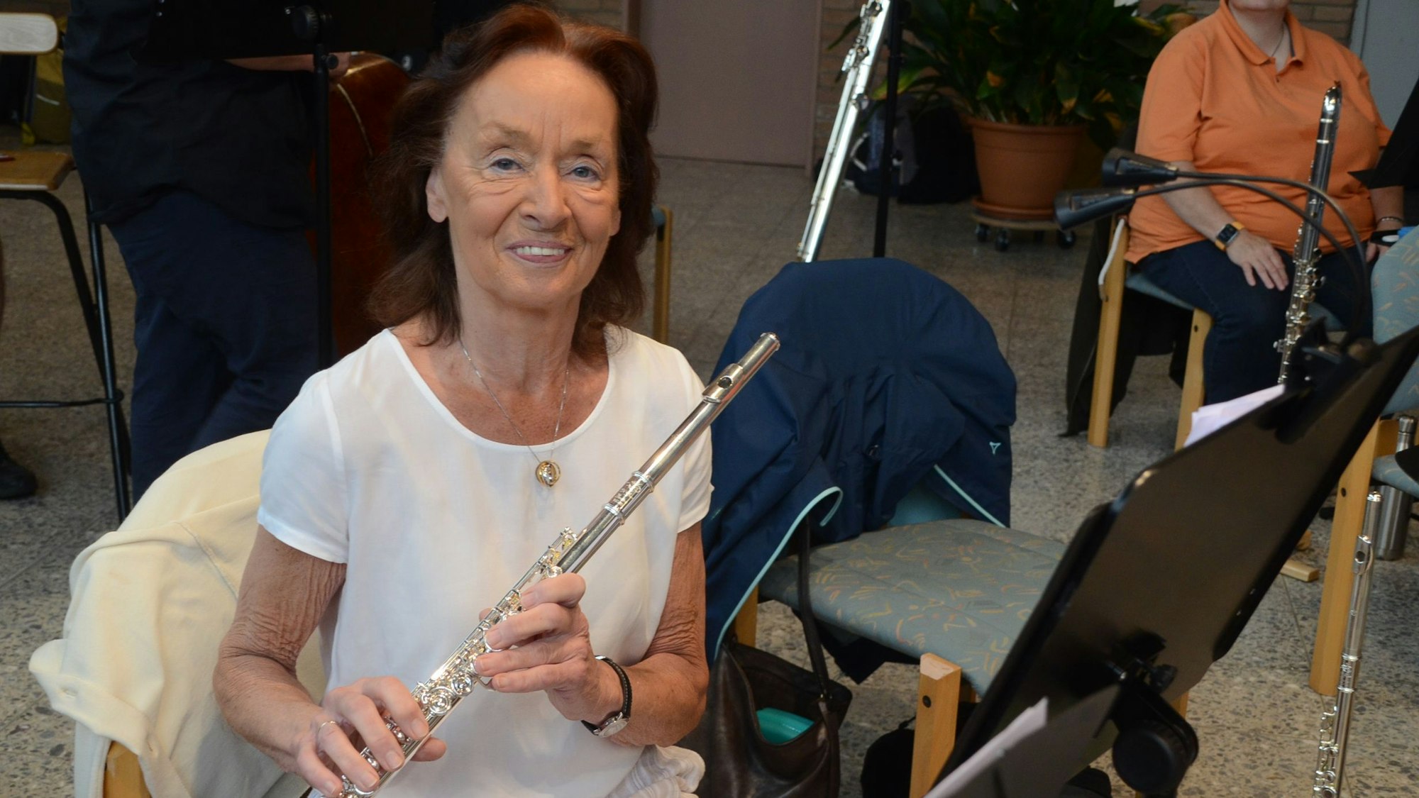 Eine Frau im weißen T-Shirt mit einer Querflöte.