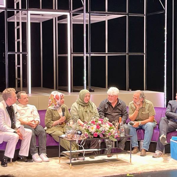 Auf einem langen lila Sofa sitzen (von links nach rechts): Thomas Laue, Stefko Hanushevsky, Meral Sahin, Ismet Büyük, Ayfer Sentürl Demir, Kutlu Yurtseven und Stefan Bachmann
