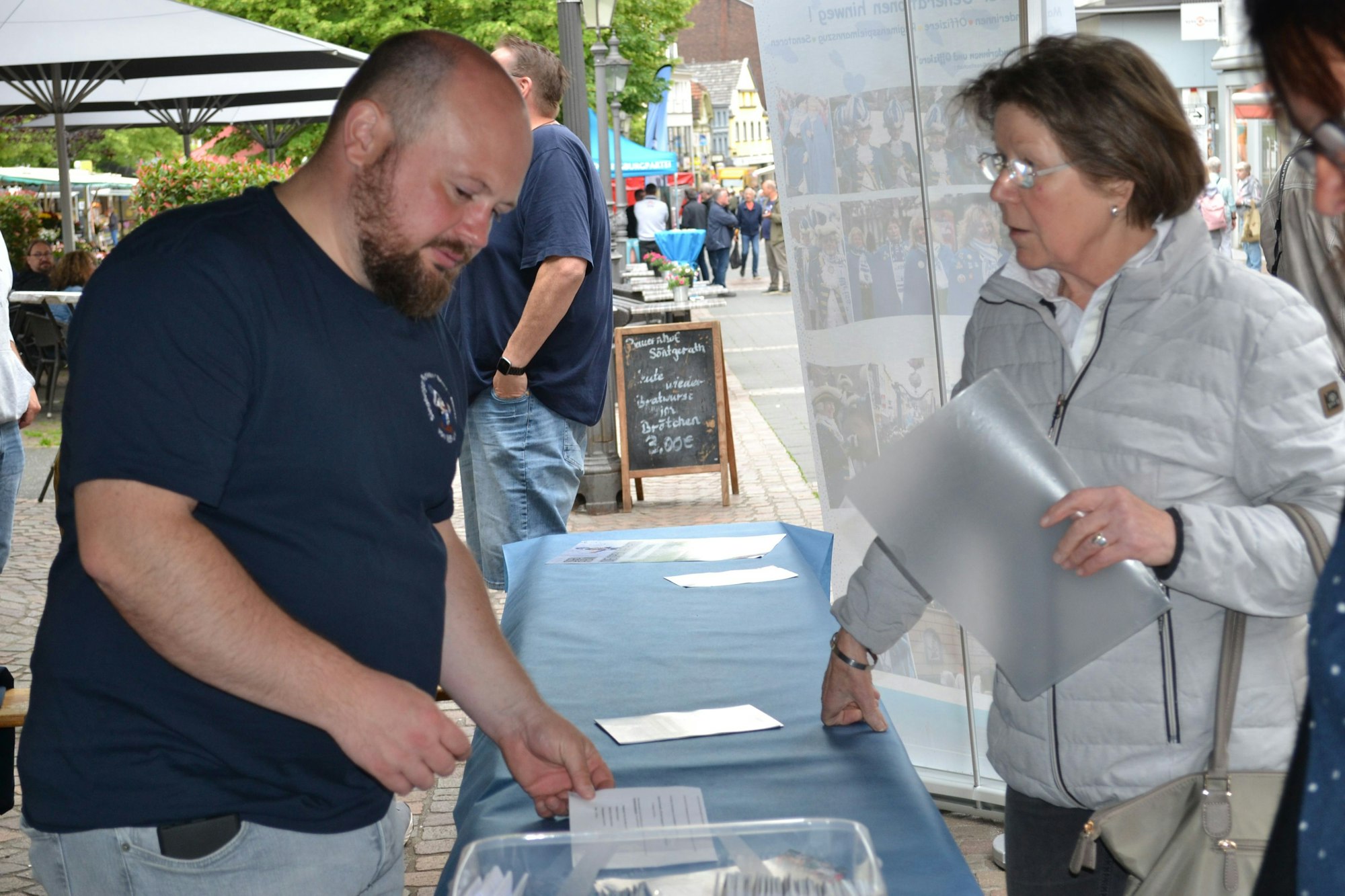 Ein Mann und eine Frau an einem Verkaufsstand.