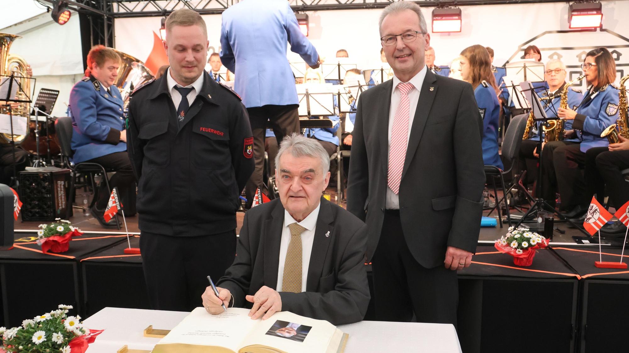 Ins Goldene Buch der Gemeinde Reichshof trug sich NRW-Innenminister Herbert Reul beim Festkommers der Löschgruppe Denklingen ein. Links Einheitsführer Kilian Siepe, rechts Bürgermeister Rüdiger Gennies.