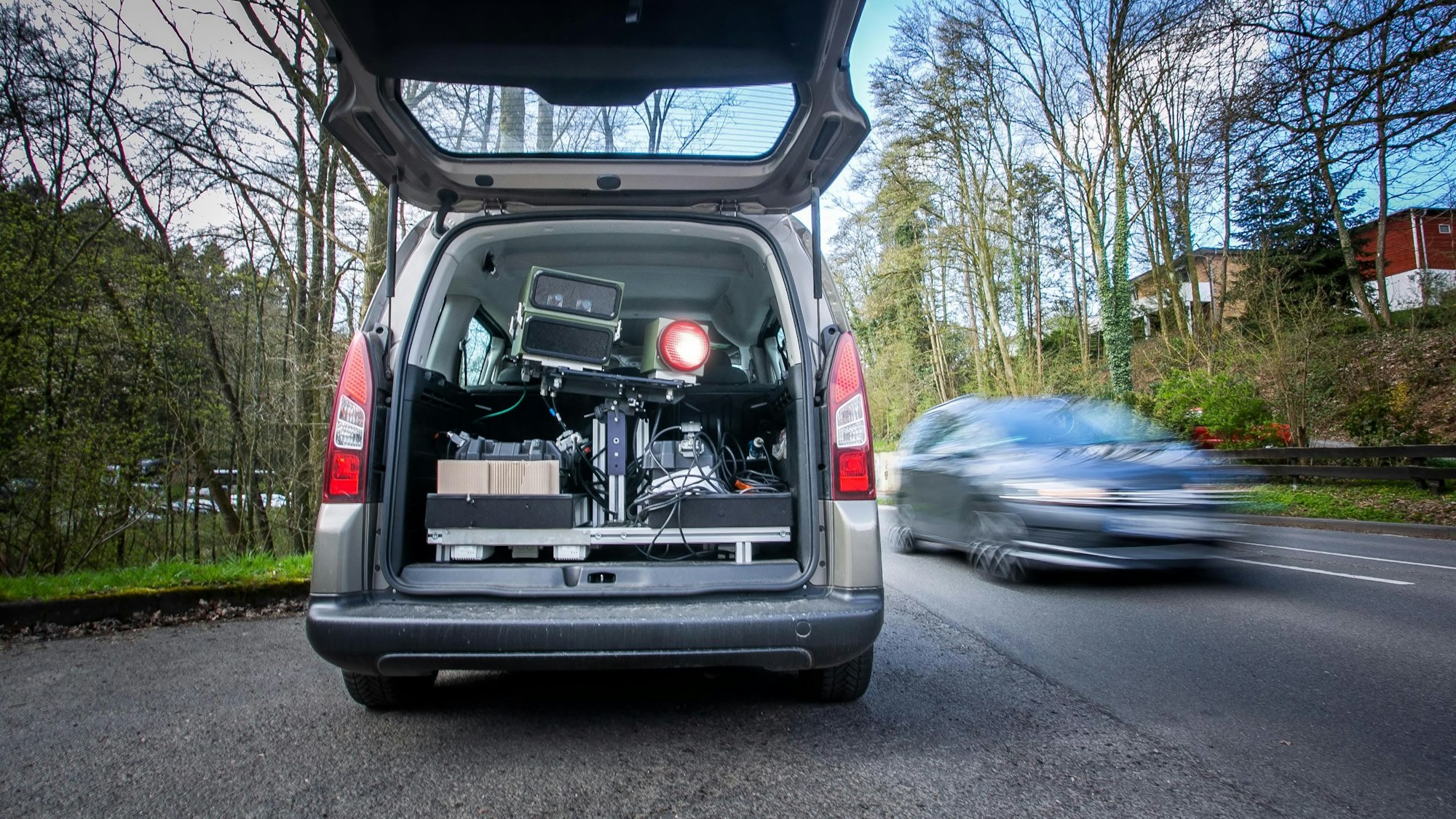 Auf dem Foto ist ein Pkw mit geöffnetem Kofferraum zu sehen, in dem eine Tempomessanlage installiert ist.
