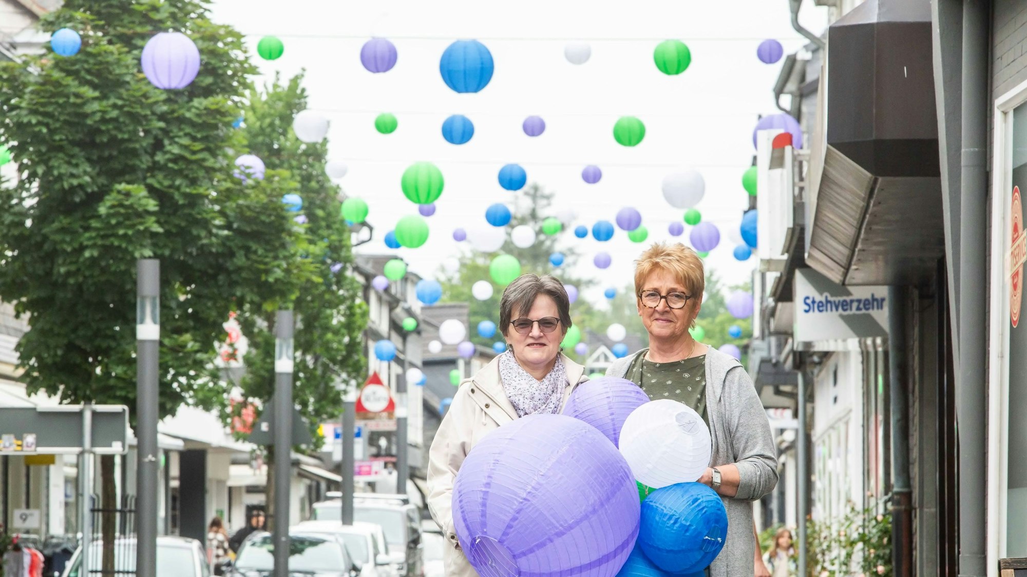 Das Foto zeigt Gaby Vossebrecher und Barbara Pier und im Hintergrund die Untere Straße mit vielen bunten Lampions.