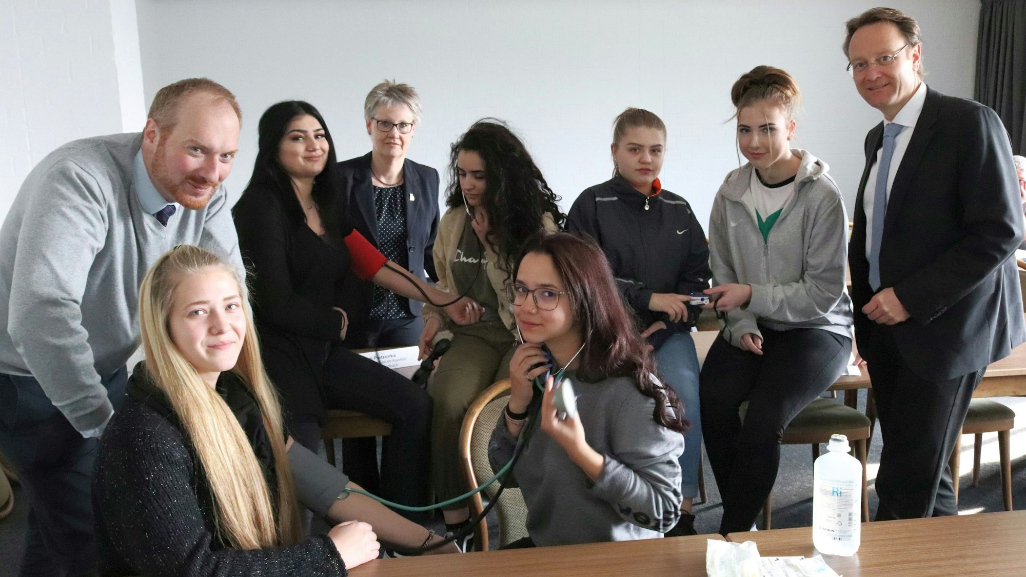 Die Teilnehmern eines dreitägige Praxiskurses sitzen mit Vertretern von Handwerk und Berufsschulen in einem Klassenraum in Bergisch Gladbach.