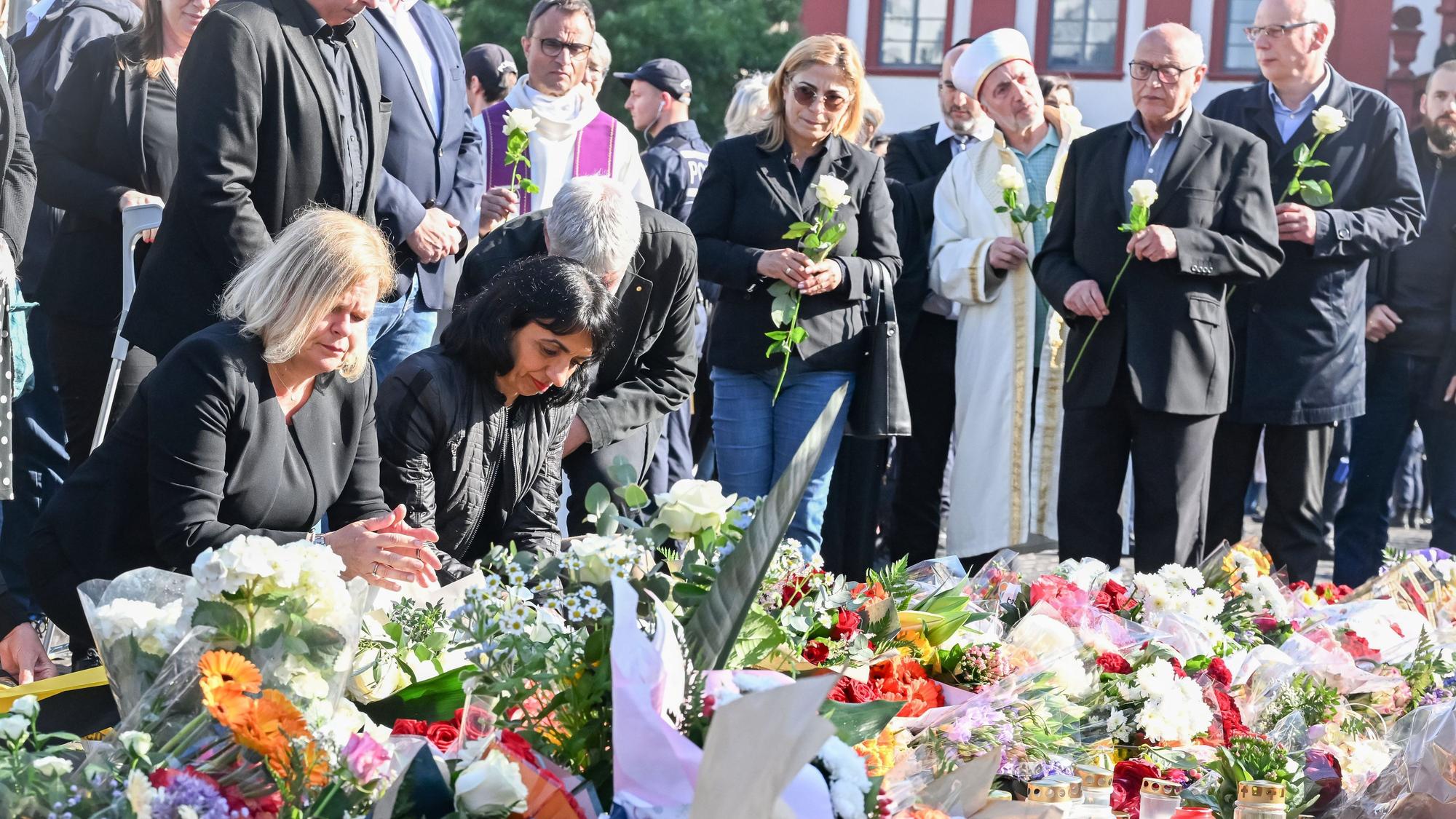 Bundesinnenministerin Nancy Faeser (l.SPD) legt zusammen mit Muhterem Aras (Bündnis 90/Die Grünen), Präsidentin des baden-württembergischen Landtags, am Marktplatz Blumen für einen bei einer Messerattacke getöteten Polizisten nieder.