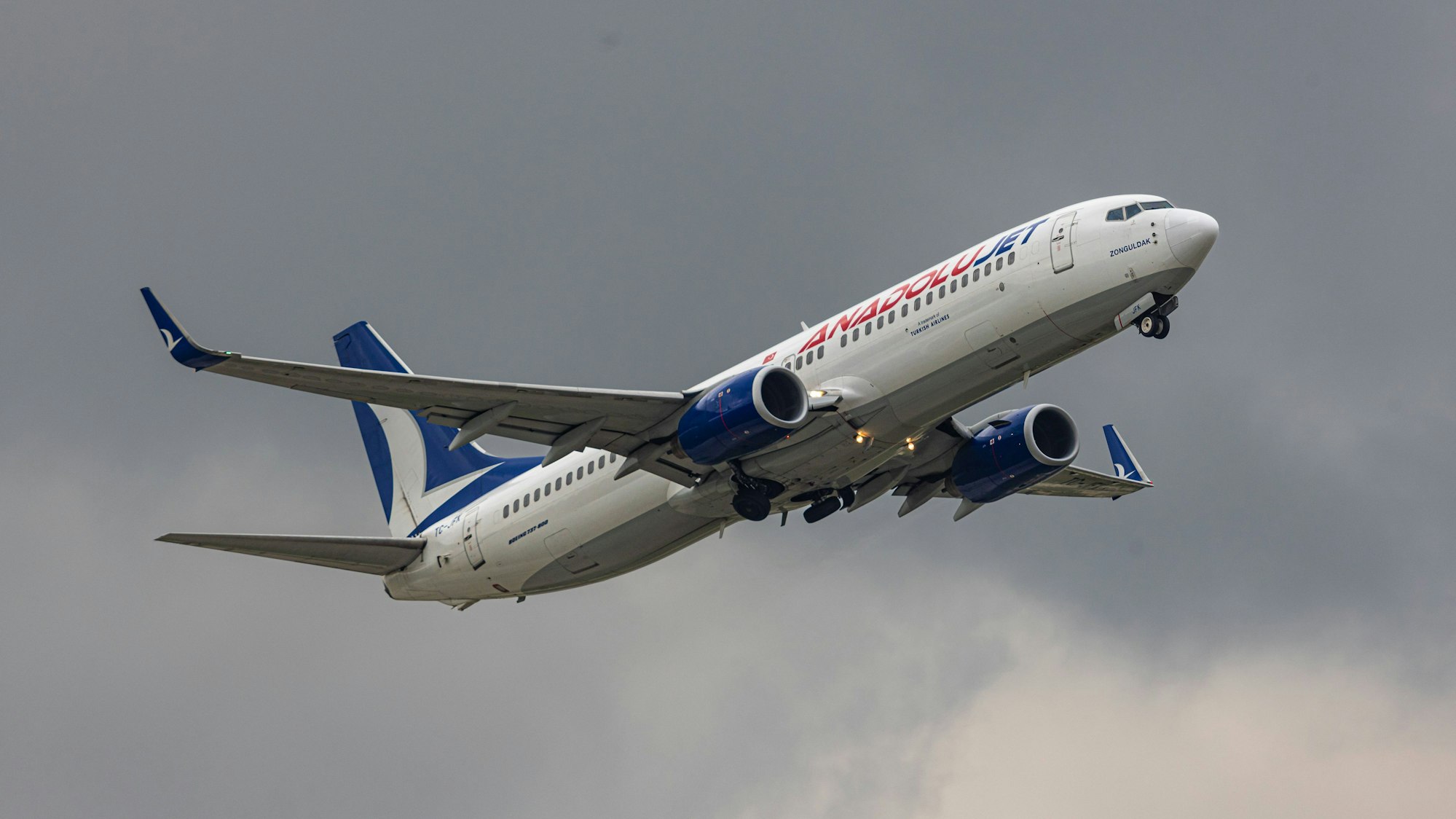Eine Boeing 737 der türkischen Fluggesellschaft Ajet kurz nach dem Start in einem Unwetter. Das Flugzeug ist vor grauen Gewitterwolken im Steigflug. (Symbolbild)