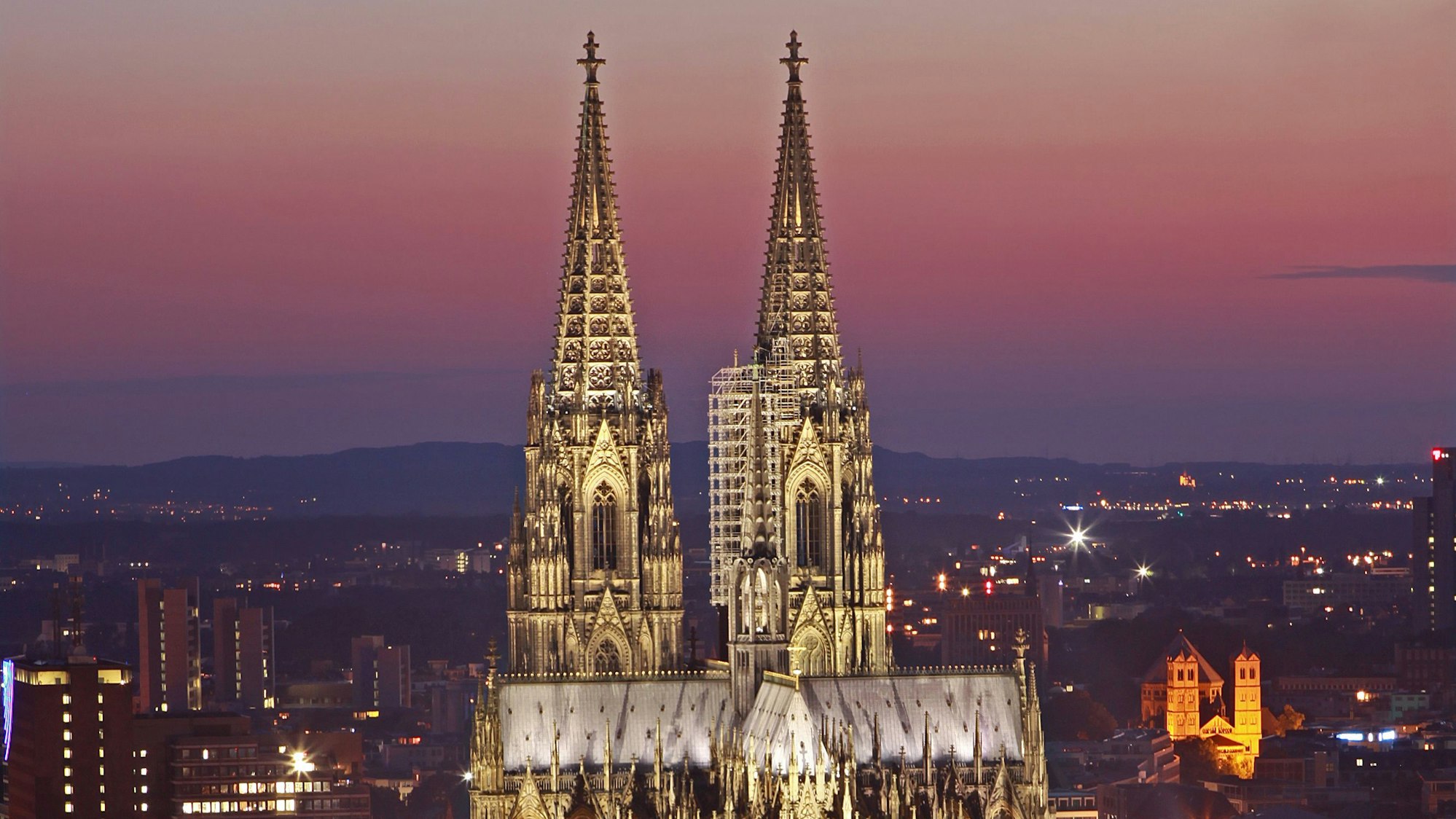 Zu sehen ist der beleuchtete Kölner Dom in der Außenansicht am Abend.