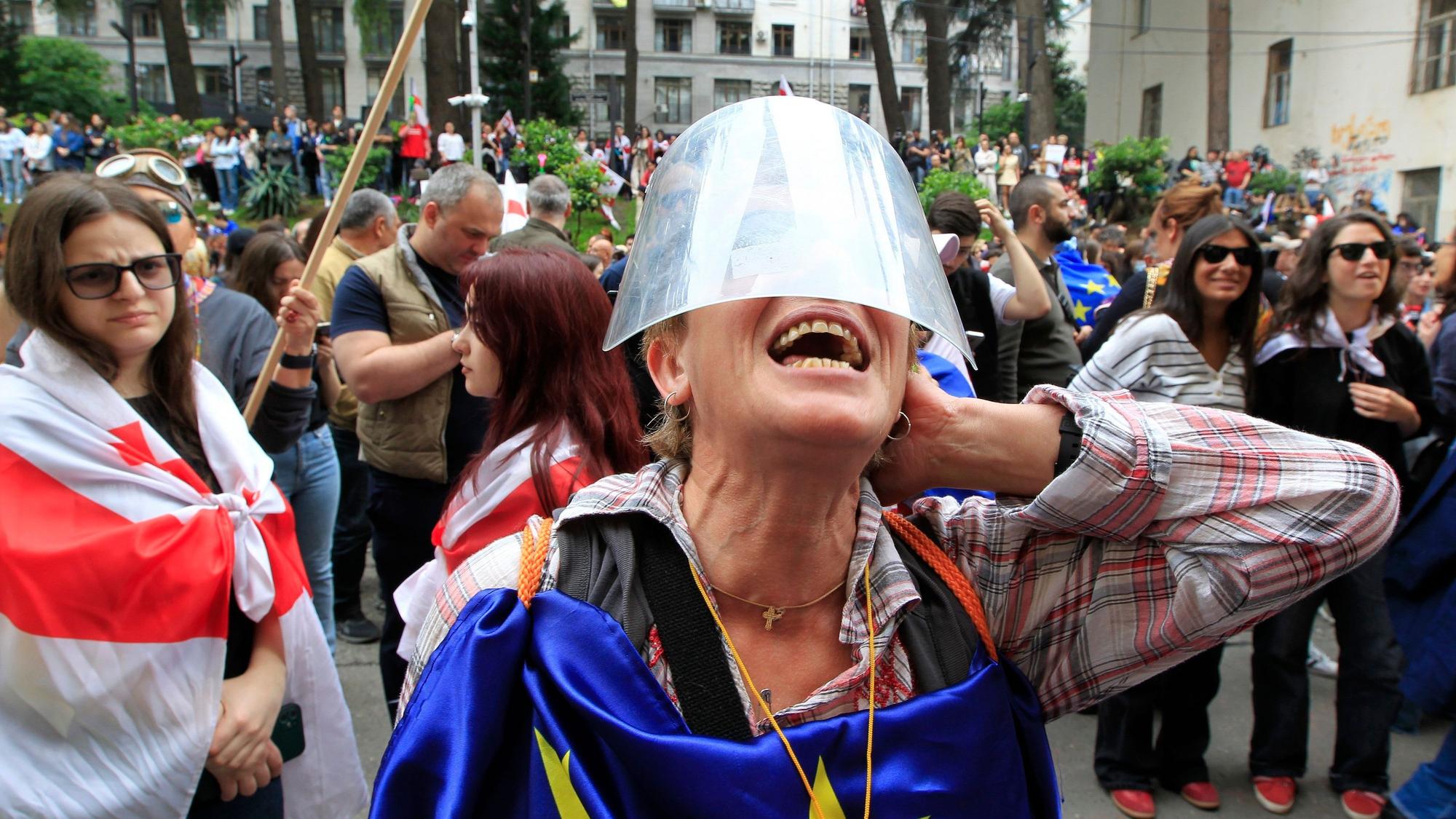 ARCHIV - 28.05.2024, Georgien, Tiflis: Eine Demonstrantin ruft während eines Protestes der Opposition gegen das Gesetz über ausländische Einflussnahme vor dem Parlamentsgebäude.