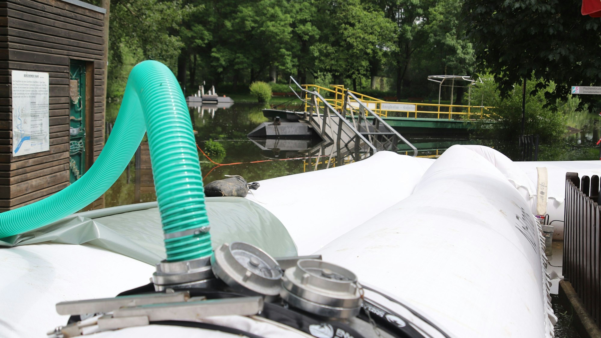 Wasser aus der Sieg wird in die Plastikschläuche gepumpt, bis sie ihre volle Höhe erreicht haben.