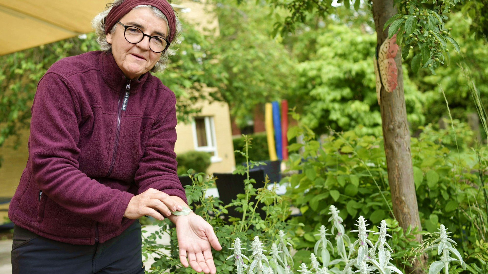 Ulrike Kreuer streicht sich mit einem hellgrünen Blatt über den Unterarm.